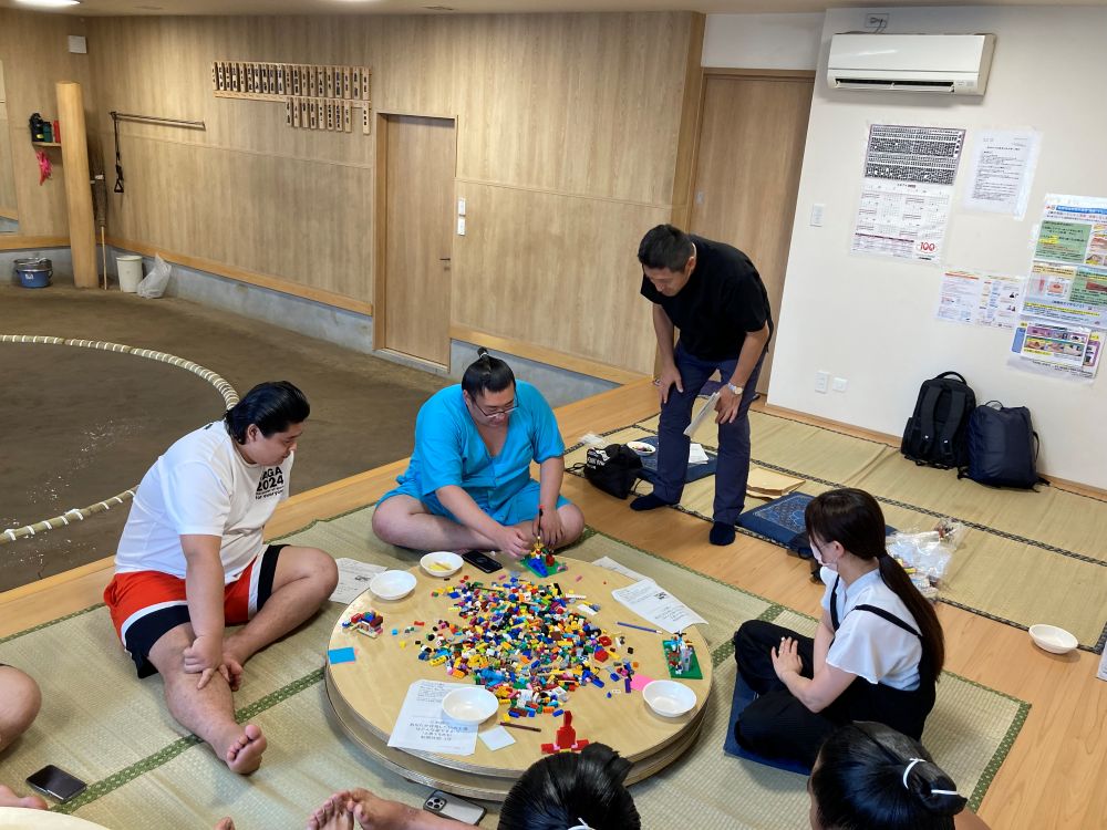 おかみさんと力士が聞き入る